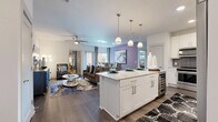This well-appointed 2-bedroom, 3-bathroom single-floor residence offers a thoughtfully designed open-concept layout that seamlessly connects the kitchen, dining, and living areas. The kitchen is a standout feature, boasting crisp white cabinetry, a gray subway tile backsplash, stainless steel appliances, and a granite-topped island with pendant lighting and bar seating — ideal for both cooking and casual entertaining. Rich hardwood-style flooring runs throughout the main living areas, complemented by a ceiling fan and generous natural light from large windows.

The living and dining spaces flow effortlessly together, with a soft accent wall adding a touch of color and depth to the open layout. The primary bedroom offers carpeted flooring, a walk-in closet with adjustable shelving, and a private en-suite bathroom featuring an extended granite vanity, white cabinetry, and large-format tile flooring. A second bedroom and additional bathrooms provide ample space for guests or household members.

The residence includes two closets for generous storage, a dedicated laundry room with a full-size washer and dryer, and a connecting hallway that ties the layout together efficiently. The overall aesthetic is modern and cohesive, with neutral tones, granite surfaces, and contemporary fixtures throughout.