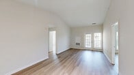 Located at 4901 Meridian Way in Frederick, Maryland, this 2-bedroom, 2-bathroom residence offers a thoughtfully designed single-floor layout with a clean, contemporary aesthetic. Light-toned hardwood-style flooring runs throughout the home, creating a bright and cohesive feel. The living room stands out with soaring vaulted ceilings and access to the outdoors through a pair of windows, filling the space with natural light and an open, airy atmosphere. The kitchen is outfitted with white shaker-style cabinetry, light quartz countertops, a white tile backsplash, and a full suite of stainless steel appliances including a refrigerator, dishwasher, and gas range. An adjacent dining area benefits from additional natural light through a street-facing window. The spacious primary bedroom features vaulted ceilings, large windows with outdoor views, and a dedicated walk-in closet with built-in shelving. The second bedroom is a comfortable, well-proportioned room with crisp neutral walls. Both bathrooms are finished in a clean, white palette with vanities, tub-shower combinations with tile surrounds, and brushed nickel hardware. Additional hallway closets provide ample storage throughout the home.
