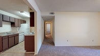 Located at 2908 Birmingham Hwy in Opelika, Alabama, this single-story unit offers a practical and well-organized layout across a comfortable footprint. The kitchen is equipped with dark espresso-toned cabinetry, a coil-burner electric range, a full-size refrigerator, and ample counter space, all finished with tile flooring for easy maintenance. The kitchen flows naturally into the main living area, which is carpeted and opens to a sliding glass door that provides access to a private outdoor patio and views of surrounding greenery.

A carpeted hallway connects the living space to the private quarters, which include multiple bedrooms. One bedroom features dual closets, offering generous storage, while another benefits from a window with natural light and outdoor views. The textured ceilings are consistent throughout the unit, lending a classic residential feel.

Two full bathrooms serve the unit, each featuring a tub-shower combination, a single-sink vanity with dark cabinetry, a large mirror, and tile flooring. The floor plan, as seen in the overhead model view, is efficiently arranged to maximize usable space throughout. Overall, the unit presents a clean, functional interior suited for everyday living.