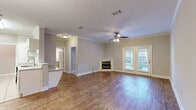 This single-story, 2-bedroom, 2-bathroom home offers a thoughtfully designed layout that balances comfort and functionality. The open-concept living area is a standout feature, showcasing warm hardwood flooring, crown molding, and a ceiling fan that enhance the inviting atmosphere. A corner fireplace adds a cozy focal point, while French doors flood the space with natural light and provide access to the outdoors. A chandelier adds an elegant touch near the entryway hallway.

The galley-style kitchen is efficiently designed with white cabinetry, granite countertops, a classic subway tile backsplash, and stainless steel appliances, including a refrigerator, range, and dishwasher. A peninsula counter connects the kitchen to the main living area, making it ideal for entertaining.

The generously sized primary bedroom offers ample space, plush carpeting, and a ceiling fan, while the second bedroom also features carpet flooring and dual closets. Both bathrooms are finished with tile flooring, granite-topped vanities, white cabinetry, and tub-shower combinations. A dedicated laundry room with overhead cabinetry and a full-size washer and dryer adds everyday convenience to this well-rounded home.