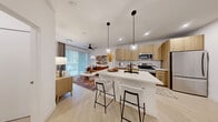 Located at 3930 Paradise Rd in Las Vegas, NV, this thoughtfully designed one-bedroom, one-bathroom residence offers a modern aesthetic with an efficient, well-appointed layout. The open-concept kitchen and living area serves as the heart of the home, where light wood cabinetry, a white quartz waterfall island with bar seating, stainless steel appliances, and globe pendant lighting come together to create a sleek, contemporary atmosphere. Light-toned luxury vinyl plank flooring runs throughout the main living areas, enhancing the bright and airy feel of the space. The living area features a ceiling fan, large sliding glass door with vertical blinds that invite natural light, and ample room for comfortable furnishings. The bedroom is a calm retreat with plush carpeting, a generously sized window, and access to a well-organized walk-in closet outfitted with multi-tiered shelving and hanging rods. The bathroom offers a clean, minimalist design with a subway-tiled tub-shower combination and neutral tile flooring. An entry nook with additional storage provides a welcoming transition into the home. Throughout, the design balances clean lines with warm natural wood tones, creating a cohesive and inviting living environment.