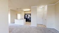 This well-appointed 2-bedroom, 1-bathroom residence is thoughtfully laid out across a single floor, offering a comfortable and functional living environment. The open-concept main living area seamlessly integrates the living room, dining space, and kitchen, creating an expansive, connected feel. The living room features plush carpeting, crown molding, a ceiling fan, and multiple windows dressed with blinds that allow natural light to fill the space. A door provides direct exterior access from the living area.

The kitchen is equipped with dark espresso cabinetry, granite-style countertops, tile flooring, and a full suite of black appliances including a refrigerator, electric range, built-in microwave, and dishwasher. A peninsula with a double stainless steel sink serves as both a workspace and a divider between the kitchen and living areas, with track lighting overhead adding a functional accent.

The primary bedroom is generously sized, featuring carpeting and direct access to the bathroom. The second bedroom offers carpeted flooring and a large window that brings in ample natural light. The bathroom includes a double-sink vanity with granite-style countertops, dark cabinetry, tile flooring, and a tub-shower combination. Additional highlights include five closets throughout and a dedicated laundry area.