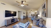 Located at 1367 N Merion Way in Fayetteville, Arkansas, this single-story 2-bedroom, 2-bathroom home offers a well-organized, functional layout across a comfortable footprint. The open-concept living area is anchored by durable wood-look flooring, vaulted ceilings, and a ceiling fan with light kit, creating a bright and airy atmosphere. Large windows allow natural light to fill the space, while multiple seating areas make the living room both practical and inviting.

The kitchen features white cabinetry with dark countertops, white appliances including a refrigerator, dishwasher, and range, and a peninsula breakfast bar with seating — ideal for casual dining. A dedicated dining area sits adjacent, completing the open communal zone.

Both bedrooms are carpeted and equipped with ceiling fans. The primary bedroom is generously proportioned, offering ample space and access to multiple closets. The second bedroom is well-sized with its own closet access. A hallway connects the private quarters to the rest of the home.

The two bathrooms each feature a tub-shower combination with sliding glass doors, a single-sink vanity with storage cabinetry, and wood-look flooring. Three closets throughout the home provide strong storage capacity. The overall design is clean, neutral, and move-in ready.