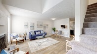This two-story, 1-bedroom, 2-bathroom home is thoughtfully designed to maximize comfort and functionality across two well-proportioned floors. The main level features an open-concept living and dining area bathed in natural light from large windows, with warm wood-look flooring that flows seamlessly throughout. The living room offers generous space for entertaining, while a pass-through window connects the dining area to the kitchen, enhancing the open feel. The galley-style kitchen is equipped with gray shaker cabinetry, granite-look countertops, black appliances including a gas range and dishwasher, and ample storage. A convenient closet and a half bathroom with a granite vanity and gray cabinetry complete the main floor. The upper level is dedicated to the expansive primary bedroom, which features plush carpeting, a textured ceiling, and direct access to a full en-suite bathroom. The primary suite offers generous room for furnishings and includes a closet for added storage. The second full bathroom features a tub-shower combination with clean white tile surround. Throughout the home, a neutral color palette, textured ceilings, and consistent finishes create a cohesive and inviting atmosphere.