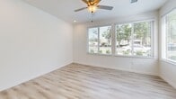 Located at 2011 Slamson Lane in Sacramento's 95811 zip code, this 2-bedroom, 1-bathroom unit offers a clean, modern aesthetic throughout its efficiently designed single-floor layout. The open living area is bright and airy, highlighted by light wood-style flooring, crisp white walls, recessed lighting, and a ceiling fan. Large windows with blinds frame views of surrounding greenery, filling the space with natural light.

The kitchen is well-appointed with white shaker-style cabinetry extending to the ceiling, stainless steel appliances including a refrigerator, range, dishwasher, and microwave, as well as light countertops and a stainless steel sink. A second utility area with additional cabinetry and a sink provides added convenience.

Both bedrooms are comfortably sized with plush carpet flooring, white walls, and windows that bring in natural light and outdoor views. The primary bedroom offers a functional layout suitable for a variety of furnishing arrangements.

The bathroom features a clean, accessible design with a combination tub and shower fitted with grab bars, a white vanity with an undermount sink, and light wood-style flooring that ties the space together. The overall ambiance of this unit is bright, fresh, and move-in ready.