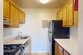 Located at 5521 Marlboro Pike in District Heights, MD, this generously sized 3-bedroom, 1-bathroom unit spans a single floor, offering a notably expansive layout well-suited for comfortable everyday living. The living area features plush carpeting and large sliding glass doors that open onto a balcony, allowing natural light to fill the space while providing open views of the surrounding neighborhood and green lawn below.

The galley-style kitchen is efficiently designed with warm oak cabinetry, light-toned countertops, a stainless steel gas range, and a black refrigerator. Tile flooring completes the functional layout, providing ample counter and storage space along both walls.

Each of the three carpeted bedrooms is finished with neutral-toned walls and clean white baseboards. The spacious primary bedroom features dual bi-fold closets, offering generous storage. Secondary bedrooms each include their own closet and windows that introduce natural light. The full bathroom is equipped with a tub-shower combination and tile flooring. Throughout, the unit maintains a clean, neutral palette that lends itself to a versatile and move-in-ready living environment.