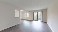 Located at 1731 NW Sixth St in Gainesville, Florida, this single-floor unit features a clean, modern aesthetic throughout. The open living area is finished with durable wood-style flooring and neutral white walls, creating a bright and versatile space. A textured ceiling adds depth, while large sliding glass doors lead to a private balcony overlooking lush, wooded surroundings, allowing generous natural light to fill the room. A pass-through window connects the living area to the kitchen, enhancing the open feel.

The galley-style kitchen is well-equipped, featuring dark shaker-style cabinetry, light granite countertops, and stainless steel appliances including a refrigerator, gas range, and dishwasher. Wood-style flooring continues seamlessly throughout.

The bedrooms are generously sized, each offering wood-style flooring, neutral tones, and windows that frame views of the surrounding tree canopy. The bathrooms are tastefully updated, with one featuring full-height grey stone-look tile surrounding a soaking tub, and another offering a dark wood vanity topped with granite and a well-lit mirror. The overall ambiance is clean, modern, and move-in ready.