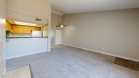 Located at 8490 Sheridan Blvd in Arvada, Colorado, this one-bedroom, one-bathroom residence offers a well-organized single-floor layout designed to maximize comfort and functionality. The living room serves as the heart of the home, highlighted by a tile-surround wood-burning fireplace, vaulted ceilings, and a large window fitted with vertical blinds that invites abundant natural light. Plush wall-to-wall carpeting flows throughout the living and bedroom areas, lending a warm, cohesive feel. A ceiling fan with a brass fixture adds both style and practicality to the open living and dining space. The kitchen is efficiently designed with warm honey-toned wood cabinetry, dark countertops, a pass-through bar opening to the living area, and durable wood-look vinyl flooring. Appliances include a white refrigerator and electric range. A hallway connects the main living area to the generously sized primary bedroom, which benefits from its own natural light source. Three closets provide ample storage throughout the home. A dedicated dining area completes the layout, making the space ideal for everyday living. The textured ceilings and neutral wall tones throughout contribute to a clean, move-in-ready aesthetic.
