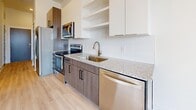 Located at 7 Vance Avenue in the heart of Memphis, TN, this thoughtfully designed one-bedroom, two-bathroom residence offers a clean, contemporary aesthetic throughout its efficiently arranged single-floor layout. Light wood-tone luxury vinyl flooring runs consistently through every room, creating a bright and cohesive feel complemented by crisp white walls and white baseboards.

The combined kitchen and living area serves as the central hub of the home. The kitchen is well-appointed with granite countertops, dark wood lower cabinetry, white upper cabinets with open shelving, a tile backsplash, and a full suite of stainless steel appliances including a range, microwave, dishwasher, and refrigerator.

The bedroom offers a comfortable footprint with large sliding glass doors that flood the space with natural light and provide views of the surrounding Memphis cityscape. A walk-in closet with wire shelving provides practical storage just off the bedroom.

Two full bathrooms serve the unit; one features a granite-topped vanity with dark cabinetry, matte black fixtures, and a soaking tub with shower combination set against clean white tile surrounds. The overall ambiance is modern, minimal, and move-in ready, ideal for those seeking stylish urban living in downtown Memphis.