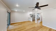Located in Metairie, Louisiana, this 2-bedroom, 1-bathroom single-floor home offers a clean, modern aesthetic with consistent light wood flooring and neutral gray walls throughout. The open kitchen and living room area is a standout feature, with white shaker-style cabinetry, white quartz countertops, stainless steel appliances including a range, microwave, and refrigerator, and crown molding that adds a refined touch. A window over the sink brings in natural light, and the layout flows seamlessly into the living area, which features recessed lighting and a built-in shelf niche. Both bedrooms are well-sized, each equipped with a ceiling fan with light, recessed lighting, and windows that allow natural light to fill the rooms. The primary bedroom includes a sliding double-door closet, offering ample storage. The second bedroom also features a ceiling fan and a window with outdoor views. The full bathroom is finished in a crisp white palette, featuring a tub-shower combination with subway tile surround, matte black hardware and fixtures, and a white vanity with matching black hardware. A hallway connects all rooms, providing a functional and organized floor plan. The home presents a fresh, move-in-ready condition throughout.