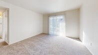 This two-bedroom, one-bathroom residence is thoughtfully arranged on a single floor, offering a functional and comfortable layout. The living area features neutral-toned carpet and a full-width sliding glass door fitted with vertical blinds, allowing natural light to fill the space and providing access to the outdoors. The galley-style kitchen is well-appointed with white cabinetry, granite-look countertops, a double basin sink, and white appliances including a refrigerator and electric range. Wood-look flooring runs through the kitchen and bathroom, adding a warm contrast to the light walls throughout. Both bedrooms are carpeted and bright, each benefiting from windows dressed with vertical blinds that allow ample natural light. The bedrooms offer generous closet space, with one featuring a spacious walk-in closet equipped with dual hanging rods for organized storage. The full bathroom includes a shower-tub combination with a clean white surround, complemented by wood-look flooring. Clean white walls and neutral finishes throughout the residence create a bright, cohesive ambiance that serves as a versatile backdrop for a variety of furnishing styles.