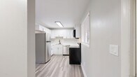 Located at 767-1A Adams Dr in Newport News, VA, this single-floor, 2-bedroom, 1-bathroom home offers a thoughtfully designed layout with modern updates throughout. The combined kitchen and living area forms the heart of the home, featuring light luxury vinyl plank flooring, neutral gray walls, and a sliding glass door in the living room that fills the space with natural light and provides views of the surrounding greenery. The kitchen is well-appointed with crisp white shaker-style cabinetry, light marble-look countertops, and a full suite of stainless steel appliances including a refrigerator, dishwasher, electric range, and over-the-range microwave. A hallway connects the living area to the two bedrooms, each finished with plush carpeting, ceiling fans, and window blinds that allow for ample natural light. The bedrooms include closet storage, with the primary bedroom offering generous proportions. The bathroom features a clean, white tub-shower surround with built-in shelving. Additional conveniences include a dedicated laundry area and utility room. With four closets throughout, storage is a practical strength of this well-maintained home.
