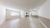 Located at 1905 Wyckshire Ct in Clarksville, Indiana, this single-floor, 2-bedroom, 2-bathroom home offers a practical and well-organized layout. The open living area is finished with light wood-style flooring, a textured ceiling, and a two-tone wall design featuring a neutral gray lower accent, creating a clean and modern aesthetic. A ceiling fan adds comfort to the main living space, which also benefits from natural light through windows fitted with blinds. The kitchen is equipped with dark cabinetry, light countertops, a tile backsplash, and a window that brings in additional natural light. Both bedrooms feature plush carpeting, providing a comfortable retreat. The spacious primary bedroom includes direct access to an en-suite bathroom as well as an adjoining closet. The bathrooms are finished with tile flooring and include a full tub-shower combination with white tile surround. A dedicated utility room houses the water heater and provides additional storage space. A connecting hallway ties the rooms together for a cohesive flow throughout the home. This residence offers a straightforward, functional design suited for comfortable everyday living.