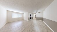 Located at 1905 Wyckshire Ct in Clarksville, Indiana, this single-floor, 2-bedroom, 2-bathroom home offers a practical and well-organized layout. The open living area is finished with light wood-style flooring, a textured ceiling, and a two-tone wall design featuring a neutral gray lower accent, creating a clean and modern aesthetic. A ceiling fan adds comfort to the main living space, which also benefits from natural light through windows fitted with blinds. The kitchen is equipped with dark cabinetry, light countertops, a tile backsplash, and a window that brings in additional natural light. Both bedrooms feature plush carpeting, providing a comfortable retreat. The spacious primary bedroom includes direct access to an en-suite bathroom as well as an adjoining closet. The bathrooms are finished with tile flooring and include a full tub-shower combination with white tile surround. A dedicated utility room houses the water heater and provides additional storage space. A connecting hallway ties the rooms together for a cohesive flow throughout the home. This residence offers a straightforward, functional design suited for comfortable everyday living.
