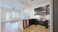 Located at 1425 Gallatin Pike N in Nashville, TN, this thoughtfully designed 2-bedroom, 3-bathroom unit offers a modern living experience across a single floor. The open-concept kitchen and living area serves as the heart of the home, showcasing dark shaker cabinetry with gold hardware, a herringbone tile backsplash, granite countertops, and a full suite of stainless steel GE appliances. A peninsula with pendant lighting provides additional workspace and casual seating, flowing seamlessly into the living area, which features light hardwood flooring and a ceiling fan. Natural light pours in through large windows and a glass exterior door, offering outdoor views. The primary bedroom is a comfortable retreat with a ceiling fan and walk-in closet equipped with built-in wire shelving. The primary bathroom features a full soaking tub with a tiled surround and matte black fixtures. The secondary bathroom continues the clean aesthetic with a granite-topped vanity, dark cabinetry, and large-format tile flooring. A second bedroom with bright windows and hardwood floors rounds out the layout. Two dedicated closets and consistent, contemporary finishes throughout give this unit a clean, well-appointed character ideal for modern Nashville living.