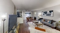 Located in Richmond, VA, this well-designed 2-bedroom, 2-bathroom residence offers a thoughtfully laid-out single-level floor plan with consistent dark hardwood-style flooring throughout. The open living and dining area serves as the heart of the home, anchored by a classic fireplace with a white mantel and flanked by windows that bring in natural light. Track lighting overhead and an adjacent dining space make this area equally suited for relaxing or entertaining.

The galley-style kitchen is efficient and stylish, featuring dark espresso cabinetry, granite-look countertops, stainless steel appliances including a refrigerator, electric range, microwave, and dishwasher, along with a pass-through that connects to the living and dining area.

The primary bedroom is a comfortable retreat with a window for natural light and room for a dedicated workspace. The second bedroom features dual windows and a built-in closet with shelving. Both rooms share neutral gray tones and dark flooring for a cohesive aesthetic.

The two bathrooms are consistent in design, each featuring dark wood vanities, granite-look countertops, and hardwood-style flooring. One bathroom includes a tub-shower combination. Hallways connect the rooms efficiently, completing this well-organized and functional residence.