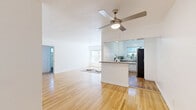 Located in the heart of West Hollywood, this one-bedroom, one-bathroom residence at 1119 N Hayworth Ave offers a well-planned layout across a single floor. The living room is bright and airy, featuring warm hardwood floors, white walls, and large windows that invite natural light. A ceiling fan adds comfort, while the open sightline toward the kitchen creates a cohesive, functional flow throughout the main living area. The kitchen is thoughtfully designed with white cabinetry, subway tile backsplash, grey countertops, and a stainless steel gas range. A window above the sink provides natural light and ventilation, completing the clean, practical aesthetic. The bedroom is a comfortable retreat, carpeted for warmth and equipped with a ceiling fan, window blinds, a wall-unit air conditioner, and a closet. The bathroom is finished with classic white subway tile extending from floor to ceiling in the shower/tub surround, complemented by a white vanity with brushed nickel fixtures and a window that allows natural light. A connecting hallway ties the rooms together efficiently. The overall design is clean and neutral, providing a versatile canvas throughout.