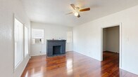 Located at 17 Norwood St in Houston, TX, this single-story, one-bedroom, one-bathroom home offers a well-organized layout with distinct living spaces connected by a central hallway. Rich hardwood flooring flows throughout the main living areas and bedroom, lending warmth and continuity to the interior.

The living room is a standout space, anchored by a classic brick fireplace and fitted with a ceiling fan. Two windows allow natural light to fill the room, while an entrance area with front-facing windows provides pleasant outdoor views. The bedroom continues the hardwood flooring theme, features its own ceiling fan, and offers access to a dedicated closet, providing practical storage.

The kitchen is well-appointed with extensive white cabinetry — both upper and lower — granite-look countertops, a double-basin stainless steel sink, a stainless steel refrigerator, and light tile flooring. A window above the sink brings in additional natural light. The bathroom is clean and functional, featuring tile flooring and a tall storage cabinet for added organization.

Throughout the home, the white walls and bright finishes create a clean, airy atmosphere. The thoughtful floor plan makes efficient use of space, with each room clearly defined and easily accessible, making this home a practical and comfortable residence in Houston's 77011 area.