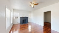 Located at 17 Norwood St in Houston, TX, this single-story, one-bedroom, one-bathroom home offers a well-organized layout with distinct living spaces connected by a central hallway. Rich hardwood flooring flows throughout the main living areas and bedroom, lending warmth and continuity to the interior.

The living room is a standout space, anchored by a classic brick fireplace and fitted with a ceiling fan. Two windows allow natural light to fill the room, while an entrance area with front-facing windows provides pleasant outdoor views. The bedroom continues the hardwood flooring theme, features its own ceiling fan, and offers access to a dedicated closet, providing practical storage.

The kitchen is well-appointed with extensive white cabinetry — both upper and lower — granite-look countertops, a double-basin stainless steel sink, a stainless steel refrigerator, and light tile flooring. A window above the sink brings in additional natural light. The bathroom is clean and functional, featuring tile flooring and a tall storage cabinet for added organization.

Throughout the home, the white walls and bright finishes create a clean, airy atmosphere. The thoughtful floor plan makes efficient use of space, with each room clearly defined and easily accessible, making this home a practical and comfortable residence in Houston's 77011 area.