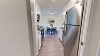 Located in San Francisco's Diamond Heights neighborhood, this well-appointed 3-bedroom, 2-bathroom residence offers a thoughtfully designed single-level layout. The galley-style kitchen is a standout feature, showcasing white shaker cabinetry, stainless steel appliances including a refrigerator, range, and built-in microwave, sleek countertops, and a classic white subway tile backsplash. The kitchen flows seamlessly into a dedicated dining area, which is bright and welcoming with hardwood-style flooring and space for a full dining set. The living room is generously sized, filled with natural light from large sliding glass doors that open to an outdoor balcony with views of surrounding greenery. The three bedrooms are carpeted for comfort, each offering ample space and natural light through well-sized windows. The spacious primary bedroom provides a serene retreat. The two bathrooms are clean and functional, one featuring a glass-enclosed shower. Throughout the home, hardwood-style flooring in the main living areas, a neutral color palette, and textured ceilings contribute to a cohesive, modern aesthetic. A hallway and dedicated closet space round out this efficiently planned residence.