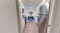Located in San Francisco's Diamond Heights neighborhood, this well-appointed 3-bedroom, 2-bathroom residence offers a thoughtfully designed single-level layout. The galley-style kitchen is a standout feature, showcasing white shaker cabinetry, stainless steel appliances including a refrigerator, range, and built-in microwave, sleek countertops, and a classic white subway tile backsplash. The kitchen flows seamlessly into a dedicated dining area, which is bright and welcoming with hardwood-style flooring and space for a full dining set. The living room is generously sized, filled with natural light from large sliding glass doors that open to an outdoor balcony with views of surrounding greenery. The three bedrooms are carpeted for comfort, each offering ample space and natural light through well-sized windows. The spacious primary bedroom provides a serene retreat. The two bathrooms are clean and functional, one featuring a glass-enclosed shower. Throughout the home, hardwood-style flooring in the main living areas, a neutral color palette, and textured ceilings contribute to a cohesive, modern aesthetic. A hallway and dedicated closet space round out this efficiently planned residence.