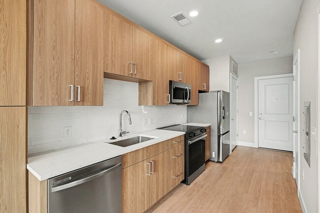 Step into modern living at Trail House Apartments. This beautifully designed kitchen features sleek appliances, abundant cabinet space, and a stylish aesthetic perfect for culinary adventures. Explore your new home today! - Trail House Apartments
