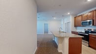 Located at 2796 Spring Orchard Ave in Mt Dora, Florida, this single-story residence offers a thoughtfully designed layout with comfortable living spaces throughout. The heart of the home is an open-concept kitchen, outfitted with rich warm-toned cabinetry, granite countertops, a herringbone tile backsplash, and a full suite of stainless steel appliances including a refrigerator, range, and built-in microwave. A granite-topped kitchen island with an undermount sink provides additional prep space and flows seamlessly into the adjacent living and dining areas, all finished with durable wood-look tile flooring. The carpeted living spaces are bright and open, with recessed lighting and ceiling fans adding comfort and functionality. Bedrooms are generously sized, featuring plush carpet, neutral toned walls, and windows that bring in natural light. One bedroom includes a spacious walk-in closet with multi-tier wire shelving systems offering ample storage. The bathrooms are well-appointed with granite vanities, warm wood cabinetry, wood-look tile floors, and full tub-shower combinations with white subway tile surrounds and chrome fixtures. The overall aesthetic is clean, neutral, and move-in ready.