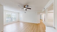 Located at 33 Constellation Cir in Jackson, TN, this well-appointed 2-bedroom, 2-bathroom unit offers a thoughtfully designed single-level layout. Light wood-look flooring flows consistently throughout the living spaces, creating a clean and cohesive aesthetic. The open living room is bright and inviting, featuring multiple windows with blinds that allow generous natural light, a textured ceiling, and a ceiling fan with a light fixture. The galley-style kitchen is a standout, outfitted with white shaker cabinetry extending to the ceiling, white subway tile backsplash, light countertops, a stainless steel sink and dishwasher, and additional stainless steel appliances including a refrigerator and range. Both bedrooms are well-proportioned, each featuring ceiling fans, windows with outdoor views, and access to dedicated closets. The primary bedroom is generously sized with its own closet space. The two bathrooms are finished in clean white with tub-shower combinations and chrome fixtures. A dedicated laundry room houses a full-size top-load washer and dryer with an overhead storage shelf, adding practical convenience. The overall ambiance is light, neutral, and move-in ready.