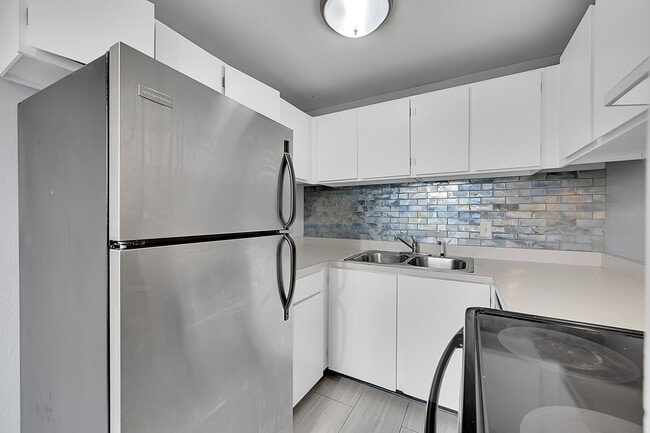 Kitchen features stainless appliances and beautiful backsplash - Vida Apartments