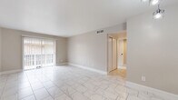 Located at 4010 Linkwood Dr in Houston, TX, this single-story 2-bedroom, 3-bathroom home offers a clean, modern aesthetic throughout. Marble-look porcelain tile flows seamlessly through the main living areas, hallways, and kitchen, creating a bright and cohesive feel. The spacious living room is bathed in natural light from a large sliding glass door with vertical blinds, opening the space to an outdoor view. A pass-through window connects the living area to the kitchen, which features granite countertops, gray shaker-style cabinetry, black appliances including a range, microwave, and dishwasher, plus a dedicated pantry for additional storage. Both bedrooms are finished with plush neutral carpet and feature generous closet space, with the primary bedroom offering a comfortable, private retreat. Three well-appointed bathrooms include granite-topped vanities with vessel sinks, gray cabinetry with black hardware, and marble-tiled tub-shower combinations. A dedicated laundry room and multiple closets throughout add to the home's practicality. The neutral color palette, consistent finishes, and efficient single-floor layout make this Houston home a functional and stylish living space.