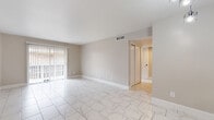 Located at 4010 Linkwood Dr in Houston, TX, this single-story 2-bedroom, 3-bathroom home offers a clean, modern aesthetic throughout. Marble-look porcelain tile flows seamlessly through the main living areas, hallways, and kitchen, creating a bright and cohesive feel. The spacious living room is bathed in natural light from a large sliding glass door with vertical blinds, opening the space to an outdoor view. A pass-through window connects the living area to the kitchen, which features granite countertops, gray shaker-style cabinetry, black appliances including a range, microwave, and dishwasher, plus a dedicated pantry for additional storage. Both bedrooms are finished with plush neutral carpet and feature generous closet space, with the primary bedroom offering a comfortable, private retreat. Three well-appointed bathrooms include granite-topped vanities with vessel sinks, gray cabinetry with black hardware, and marble-tiled tub-shower combinations. A dedicated laundry room and multiple closets throughout add to the home's practicality. The neutral color palette, consistent finishes, and efficient single-floor layout make this Houston home a functional and stylish living space.