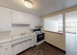 Located at 434 English St in Saint Paul, MN, this single-floor unit features a practical and well-organized layout. The kitchen is outfitted with white cabinetry extending to the ceiling, providing ample storage, along with a double-basin sink, white refrigerator, and an electric range with oven. A pass-through opening connects the kitchen to the living area, creating an open, communicative feel between the two spaces. The living area is generously sized, featuring durable wood-style flooring, neutral white walls, and a wide multi-pane window that allows natural light to fill the room. A baseboard heating system runs along the exterior wall beneath the window, ensuring warmth throughout the colder Minnesota months. The bedroom offers plush carpeting, a window with vertical blinds for privacy, and its own baseboard heating unit, making it a comfortable and quiet retreat. The bathroom is finished with full white tile surrounding a soaking tub and shower combination, complemented by a clean white vanity and mirror. Throughout the unit, consistent wood-tone trim accents the neutral color palette, contributing to a cohesive and tidy aesthetic. The overall ambiance is clean, bright, and move-in ready.