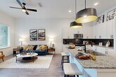 Located at 397 N Central Ave in Hapeville, GA, this well-appointed one-bedroom, one-bathroom unit offers a thoughtfully designed open-concept floor plan with modern finishes throughout. Light-toned hardwood-style flooring and crisp white walls create a bright, cohesive aesthetic across the living areas.

The kitchen is a standout feature, showcasing white shaker-style cabinetry extending to the ceiling for generous storage, granite countertops, a dark subway tile backsplash, stainless steel appliances, and a peninsula island with seating — illuminated by striking black pendant lights. The kitchen flows seamlessly into the living area, which benefits from large windows that invite natural light and provide outdoor views, complemented by a ceiling fan overhead.

The bedroom is a comfortable, well-lit retreat with a large window and plush carpeting. The full bathroom features wood-look tile flooring, granite vanity countertops, black hardware accents, and a full tub-shower surround clad in large-format marble-look tile. A dedicated laundry area houses a stacked full-size washer and dryer for added convenience.

Throughout the unit, elevated details such as tall ceilings, recessed lighting, and bold grey panel doors contribute to a polished, contemporary ambiance.