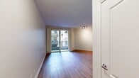 This 520-square-foot, one-bedroom, one-bathroom apartment is located at 13603 Marina Pointe Dr., Unit D515, in Marina Del Rey, CA. The single-floor layout is efficiently designed, encompassing a combined kitchen and living room, a bedroom, a full bathroom, and a hallway entry. The living area features hardwood-style flooring throughout and is bathed in natural light from large sliding glass doors that open onto a private balcony, offering views of the surrounding building courtyard. The open-concept kitchen is equipped with modern cabinetry, granite countertops with an integrated sink, a gas range, microwave, and a stainless steel refrigerator, all flowing seamlessly into the living space. Track lighting overhead adds a contemporary touch to the kitchen-living area. The 130-square-foot bedroom is carpeted and features a sliding mirrored closet with built-in shelving, along with a window that brings in additional natural light. The full bathroom includes wood-style tile flooring, a soaking tub with shower, a granite-topped vanity, and clean white finishes throughout. A welcoming entry hallway with hardwood-style flooring and a modern flush-mount light fixture completes this well-appointed coastal apartment.