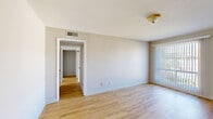 Located at 6600 Lancaster Rd in Little Rock, Arkansas, this single-story, 3-bedroom, 1-bathroom home offers a functional and straightforward layout across one level. The living room features light wood-style laminate flooring and a large window with vertical blinds, allowing natural light to fill the space. A hallway connects the living area to the rest of the home, leading to three bedrooms, each carpeted and equipped with its own closet — five closets total throughout the home provide ample storage. The primary bedroom is a comfortable size and includes a dedicated closet. The kitchen and dining area share an open combined space finished with light tile flooring. The kitchen features white cabinetry, dark countertops, and includes a refrigerator and range. A window in the dining area brings in natural light and provides outdoor views. The full bathroom is tiled floor-to-ceiling in a neutral stone-toned tile and includes a tub/shower combination, a vanity with sink, and a window for ventilation and light. A utility room and additional hallway space round out the layout. The home presents a clean, neutral palette throughout, offering a practical living environment.