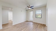 Located at 3681 Michigan Ave in Fort Myers, FL, this well-designed unit offers three bedrooms and three full bathrooms across a single floor. The open-concept kitchen and living area serves as the heart of the home, showcasing bright white shaker cabinetry, stainless steel appliances including a refrigerator, oven, and built-in microwave, and a large central island with a sleek white countertop and undermount sink — all illuminated by recessed panel lighting overhead. Light wood-look flooring runs seamlessly throughout every room, creating a clean, cohesive aesthetic. The living area features a ceiling fan and multiple windows with blinds that invite natural light and provide views of the surrounding greenery. Each bedroom is comfortably proportioned, with ceiling fans, windows offering outdoor views, and neutral white walls. The primary bedroom includes a double-door closet for generous storage. The bathrooms maintain the clean, modern palette with white tile surrounds, tub/shower combos, and consistent wood-look flooring. A central hallway connects the bedrooms and bathrooms with ease. The kitchen area also includes ample lower and upper cabinetry with brushed nickel hardware, providing abundant storage throughout this bright and functional home.