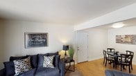 Located at 4910 Camden St in Indianapolis, Indiana, this single-floor residence offers a practical and comfortable layout designed for everyday living. The living room serves as the heart of the home, featuring warm hardwood-style flooring near the entryway that transitions to carpet, a large sliding glass door dressed with vertical blinds that invites natural light and outdoor views, and a welcoming atmosphere throughout.

The kitchen is well-appointed with warm oak cabinetry offering generous storage, light countertops, black appliances including a range and dishwasher, and hardwood-style flooring. An adjacent dining area provides a dedicated space for meals and easily accommodates a full dining set.

The primary bedroom is generously sized, featuring plush carpet, neutral walls, and dual windows that allow for ample natural light and outdoor views. A second bedroom offers similar comfort with carpet flooring, bright windows, and a calm, neutral palette — ideal as a guest room or home office.

The bathroom is clean and functional, featuring a vanity with oak cabinetry, a tub-shower combination, and hardwood-style flooring. Throughout the home, the consistent neutral tones, practical finishes, and thoughtful layout create a cohesive and move-in-ready living environment.