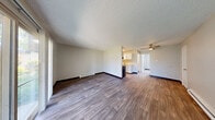 Located at 4455 NE 12th St in Renton, WA, this one-bedroom, one-bathroom unit offers a practical and well-organized single-floor layout. The open kitchen and living area serves as the heart of the home, featuring wood-style vinyl flooring, a textured ceiling, and baseboard heating. The galley-style kitchen is equipped with white cabinetry, light countertops, a stainless steel sink, and black appliances including a range and refrigerator. The living area provides a comfortable gathering space with a sliding glass door that opens to a view of outdoor greenery, allowing natural light to fill the room. The bedroom is carpeted for comfort, includes a dedicated closet, and features a window with blinds that brings in additional natural light. The bathroom is clean and functional, featuring wood-style flooring, a white vanity with under-sink storage, and a full tub-shower combination. Neutral wall tones and consistent finishes throughout the unit create a cohesive and understated aesthetic. Baseboard heaters are present in multiple rooms, providing reliable warmth. The layout makes efficient use of the available space, offering clearly defined living, sleeping, and storage areas suited for comfortable single-occupant or couple living.