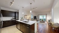 This well-appointed 2-bedroom, 2-bathroom home in Plymouth, MA offers a thoughtfully designed single-floor layout. The open-concept kitchen, dining, and living area serves as the heart of the home, featuring vaulted ceilings, pendant lighting, and a large center island with a white quartz countertop, undermount sink, and dark cabinetry. Stainless steel appliances and tile flooring complete the kitchen, which flows seamlessly into the living area with rich hardwood floors. The living room is bathed in natural light from a sliding glass door that opens to a private outdoor balcony with views of lush greenery. The primary bedroom is generously sized with plush carpeting, a ceiling fan, and a large window. It includes a spacious walk-in closet with built-in shelving and a dedicated en-suite bathroom featuring a dual-sink vanity with dark cabinetry, a soaking tub, and a separate shower. The second bedroom offers similarly comfortable finishes with ample natural light. A welcoming hallway with hardwood flooring and clean white walls connects the living spaces cohesively. This home combines functional design with refined finishes throughout.