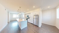 Located at 1660 Metro Ave in Chula Vista, CA, this well-appointed three-story home offers 3 bedrooms, 4 bathrooms, and a thoughtfully designed layout spread across three distinct levels. The ground floor houses an attached garage with an automatic door opener, providing convenient direct-access parking and additional storage. The main living level features an open-concept kitchen and living room highlighted by rich hardwood-style flooring, recessed lighting, and large windows that invite abundant natural light. The kitchen is anchored by a central island with a built-in sink, complemented by sleek white shaker cabinetry, stainless steel appliances including a gas range, microwave, and refrigerator, and stylish pendant lighting overhead. The upper floor is home to the generously sized primary bedroom, which includes a spacious walk-in closet with built-in shelving and hanging rods, along with two additional bedrooms finished with plush carpet flooring and ample natural light. The four bathrooms include tiled tub-and-shower combinations with clean, modern fixtures. A dedicated laundry area adds everyday convenience. With a bright, neutral palette and clean contemporary design throughout, this multi-story home delivers both comfort and functionality in a modern Chula Vista community.