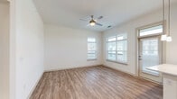 Located in the Grande Dunes community of Longs, South Carolina, this well-designed 3-bedroom, 4-bathroom single-story home offers a bright, clean aesthetic throughout. The open-concept layout connects the kitchen and living area seamlessly, with wood-look plank flooring running through the main living spaces. The kitchen is a standout feature, showcasing a central island with a white countertop and undermount sink, pendant lighting, gray cabinetry, stainless steel appliances, and recessed lighting — all complemented by generous natural light from multiple windows. A hallway connects the living area to the private bedrooms, each carpeted for comfort and equipped with ceiling fans and large windows that bring in abundant daylight and views of the surrounding community. Three well-appointed closets — including a spacious walk-in with wire shelving — provide ample storage. The four bathrooms are finished with clean, modern tile work, including a sliding glass-door shower with vertically laid white tile and brushed gold hardware. The primary bedroom is generously sized, offering a comfortable retreat. Every room reflects a neutral, move-in-ready palette with crisp white walls and thoughtful finishes throughout.
