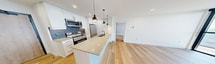 This contemporary apartment at 100 Fullarton Street, London ON, offers 740 square feet of efficiently designed living space. The unit features two bedrooms, including a primary bedroom of 180 square feet, and two full bathrooms. The open-concept layout seamlessly integrates the kitchen and living areas, creating a spacious feel within the compact footprint.

The kitchen is a highlight, boasting modern white cabinetry, stainless steel appliances, and a stylish tile backsplash. Pendant lighting and a central island with a sink enhance both functionality and aesthetic appeal. Throughout the apartment, light hardwood flooring adds warmth and continuity.

Large floor-to-ceiling windows in the living area and bedrooms flood the space with natural light and provide stunning panoramic views of the city. The bathrooms are sleek and modern, featuring clean lines, floating vanities, and glass-enclosed showers.

The apartment's design maximizes space utilization with built-in closets and storage solutions. Recessed lighting and contemporary fixtures contribute to the overall modern ambiance. This well-appointed unit offers a perfect blend of style and practicality in an urban setting.