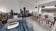 This single-floor space showcases a contemporary open-concept design that effortlessly combines a comfortable lounge area with a sleek dining bar. The most distinctive feature is a bold, hand-painted black city skyline mural spanning an entire wall, serving as a dramatic focal point that sets an urban, cosmopolitan tone throughout the space.

The lounge area is anchored by a light gray sofa accented with decorative pillows, positioned atop a rich blue abstract area rug that adds depth and texture to the light-toned tile flooring. A white oval coffee table and modular gray ottomans complete the seating arrangement, offering flexible and functional furnishing.

Flowing naturally from the lounge, the dining bar features a long white counter-height table surrounded by upholstered gray bar stools with warm wood legs. Overhead, matte black pendant lights provide focused illumination, reinforcing the modern aesthetic. Neutral gray walls and large-format light tile flooring unify the space, creating a clean, cohesive backdrop that allows the mural and furnishings to stand out. The overall ambiance is stylish, urban, and inviting.