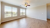 Located at 2701 Neabsco Common Pl, Unit 342 in Woodbridge, Virginia, this single-floor, 3-bedroom, 2-bathroom residence offers a thoughtfully designed layout that balances comfort and functionality. The open-concept kitchen and living area serves as the heart of the home, featuring wood-style plank flooring that flows throughout. The kitchen is outfitted with white shaker cabinetry, dark countertops, stainless steel appliances including a range, microwave, and refrigerator, and a peninsula island with a built-in sink — ideal for both cooking and casual dining. The adjoining living room benefits from natural light through large windows and is finished with crown molding and a ceiling fan. The primary bedroom is a generous, well-lit retreat with hardwood-style flooring, multiple windows with outdoor views, ceiling fan, and access to a walk-in closet with wire shelving. The secondary bedrooms feature soft carpeting, ceiling fans, and windows that invite natural light. Both bathrooms are finished with warm tile flooring and include a full tub-shower combination. A dedicated walk-in closet with wrap-around wire shelving adds practical storage to the primary suite.