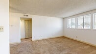 Located along Harvard Avenue in Denver, CO, this two-bedroom, one-bathroom residence offers a straightforward single-floor layout designed for comfortable, efficient living. The living area features neutral-toned carpet, a ceiling fan, and a textured ceiling, creating a welcoming entry point into the home. A hallway connects the main living space to the rest of the unit, providing a clear and organized flow throughout.

The generously sized primary bedroom is a standout feature, offering ample floor space with soft carpeting, white walls, and a large multi-pane window that brings in natural light and exterior views. The second bedroom, also carpeted with a textured ceiling, includes its own window for additional natural light.

The galley-style kitchen is efficiently arranged with white cabinetry, light countertops, tile flooring, and white appliances including a range and dishwasher, maximizing functionality within a compact footprint. A dedicated closet provides useful storage space.

The bathroom features tile flooring, a single-sink vanity with light countertops, a mirrored medicine cabinet with overhead lighting, and access to a closet. Throughout the unit, the consistent use of neutral tones, carpet, and tile creates a cohesive and clean aesthetic suitable for everyday living.