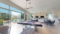 Located at 1902 Millenia Ave in Chula Vista, CA, this contemporary single-floor community clubhouse is designed with a coastal California aesthetic throughout. The open-concept game and lounge area serves as the heart of the space, featuring a sleek pool table beneath globe pendant lighting, wide-plank wood-look flooring, and generous soaring ceilings. Floor-to-ceiling sliding glass doors flood the interior with natural light and provide seamless access to the outdoor patio, which is furnished with white lounge chairs accented in teal, ideal for relaxing in the Southern California sunshine.

The kitchenette is a standout feature, showcasing bold teal cabinetry paired with dramatic black marble-veined countertops and backsplash, complemented by California-themed artwork that reinforces the coastal vibe. An adjacent bar-height counter with modern pendant lighting and upholstered seating provides a stylish gathering spot.

A dedicated lounge and co-working area features curated teal wall art, warm wood slatted accents, and a bar-style work counter with pendant lighting, creating a productive yet comfortable environment. The conference room is equally refined, with a textured wood accent wall, glass whiteboard panels, clerestory windows, and a professional conference table — well-suited for focused meetings or collaborative work sessions.