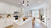 Located at 3939 State Line Rd in Kansas City, MO, this efficiently designed one-bedroom, one-bathroom residence offers a bright and modern living experience across a single floor. The open-concept layout seamlessly connects the kitchen, dining, and living areas, creating a cohesive and airy atmosphere throughout. The kitchen is a standout feature, showcasing white shaker cabinetry, stainless steel appliances, a large white quartz island with bar seating, and pendant lighting overhead — all set above warm wood-tone flooring that flows through the main living spaces. The living room is filled with natural light from a set of French doors, adding an inviting, open feel to the space. The bedroom offers plush carpeting, large windows with city views, and ample closet storage. The full bathroom features a clean white vanity with black hardware accents, a tub-shower combination, and wood-look flooring. Additional practical spaces include a dedicated laundry area and a utility room. Two closets provide generous storage throughout. The consistent white palette, recessed lighting, and carefully chosen finishes give the entire residence a fresh, contemporary character.