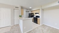 Located at 4768 W Atlantic Blvd in Coconut Creek, Florida, this one-bedroom, one-bathroom residence offers a well-organized layout across a single floor. The living room is finished with plush neutral carpeting and connects seamlessly to the dining area, creating an open and comfortable gathering space. Sliding glass doors lead from the living area to a private balcony with views of lush greenery and palm trees, bringing natural light and Florida's outdoors into the home.

The kitchen features light wood cabinetry, white countertops, tile flooring, and black appliances including a range and refrigerator. A peninsula counter separates the kitchen from the living space, offering a casual breakfast bar setup. An adjacent pantry provides additional storage, complemented by a louvered bifold closet nearby.

The bedroom is a comfortable size, carpeted, and filled with natural light from a large window overlooking the landscaped surroundings. It provides access to two closets, including a spacious walk-in closet outfitted with wire shelving on multiple walls — ideal for organized storage.

The bathroom is clean and bright, featuring a full tub-shower combination, a large vanity mirror, and well-lit fixtures. A hallway connects the main areas of the home, completing this practical and inviting Coconut Creek residence.