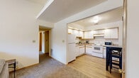 Located at 801 Lucinda Ave in DeKalb, IL, this single-floor unit offers three bedrooms, three bathrooms, and a well-organized layout designed for comfortable everyday living. The living room is a welcoming central space featuring a ceiling fan, carpet flooring, and multiple windows with vertical blinds that bring in natural light and outdoor views of the surrounding area. The kitchen is efficiently designed with white cabinetry accented by wood trim, a full suite of white appliances, and light hardwood-style flooring that extends into a dedicated dining area accommodating a bistro-style table and chairs. An adjacent utility area houses a full-size washer and dryer alongside upper cabinetry for additional storage. Each of the three bedrooms is carpeted and features windows overlooking the exterior, providing a bright and airy feel. The primary bedroom benefits from a spacious walk-in closet with wire shelving and hanging rods for ample storage. The bathrooms each include a tub-shower combination with hardwood-style flooring and granite-style countertops. Two hallways and two closets round out the functional layout, offering practical organization throughout the unit.