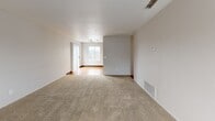 Located at 3001 N Texas St in Fairfield, CA, this single-story, one-bedroom, one-bathroom residence offers a well-organized layout across a comfortable footprint. The living room is a welcoming space anchored by a tile-surround fireplace and carpeted flooring, with natural light filtering in through windows near the front entry. The layout flows openly toward a combined dining and kitchen area, where warm-toned hardwood-style flooring contrasts rich, dark-stained cabinetry. The kitchen is equipped with ample upper and lower cabinet storage, light countertops, a stainless sink, and black appliances including a refrigerator, range, microwave, and dishwasher. A dedicated den provides additional flexible living space. The bedroom offers plush carpeting, a sliding glass door leading to a private balcony with outdoor views, a built-in vanity with dark wood cabinetry, and generous closet storage. The bathroom features matching dark wood cabinetry, a light countertop, a large mirror with overhead lighting, hardwood-style flooring, and a tub-shower combination. Multiple closets throughout the unit provide excellent storage. The neutral color palette and consistent finishes contribute to a clean, cohesive ambiance throughout the space.